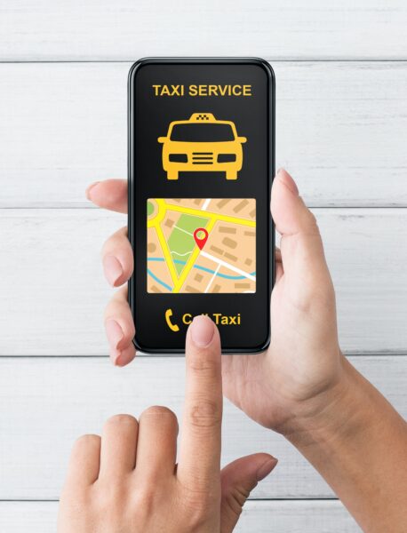 Female hand holding smartphone with taxi app interface